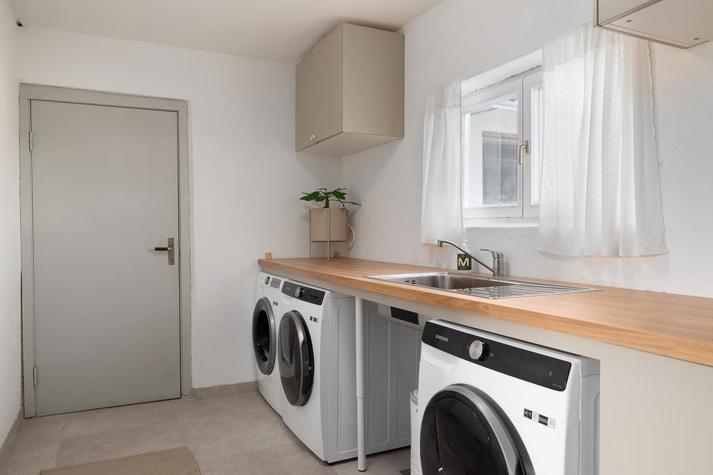 Rymlig och praktisk tvättstuga. Ingång till utrymmet under uteplatsen