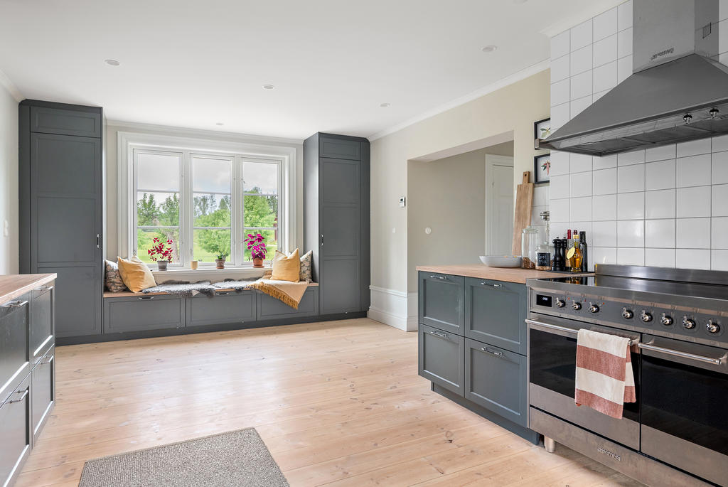 Genomtänkt planering med förvaring och sittplats vid fönstren - extra bred spis från Smeg