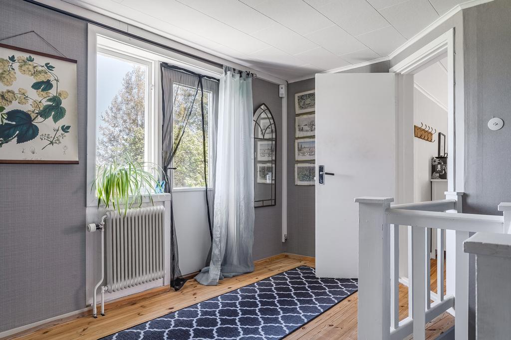 Hall ovan trapp och utgång till balkong