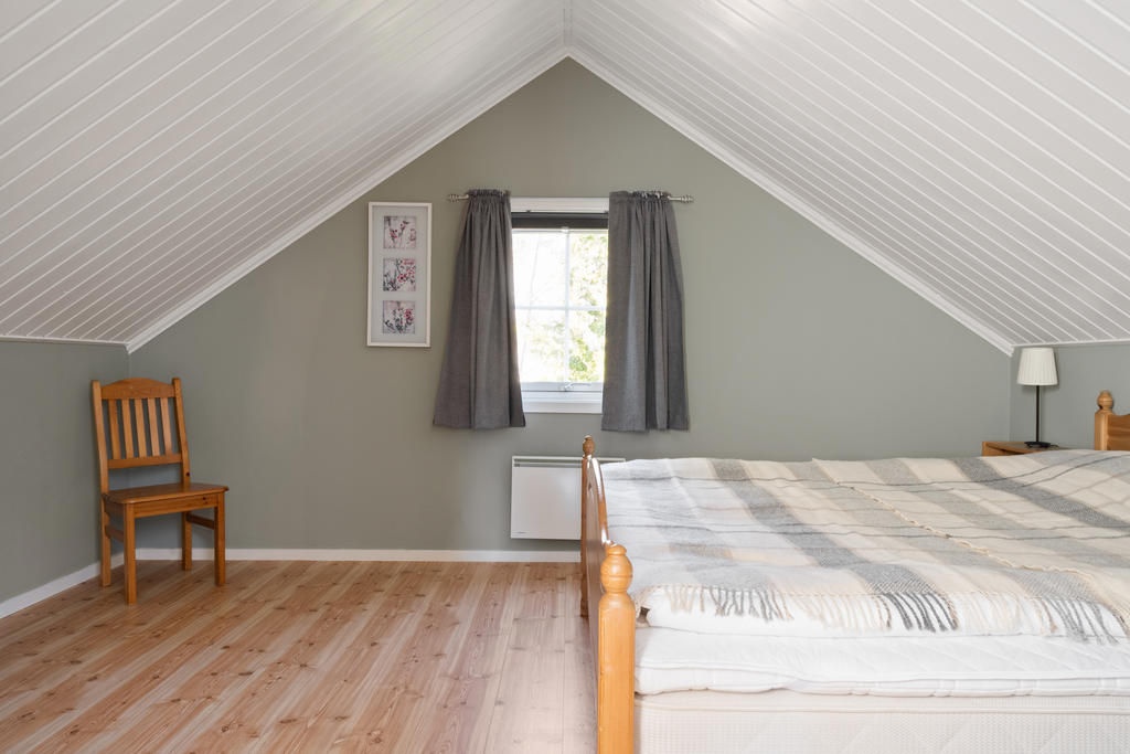 Sovrum 3 är rymligt och elegant, beläget på övre plan, och erbjuder gott om plats för en stor dubbelsäng samt förvaringsskåp, vilket skapar en inbjudande och harmonisk atmosfär.