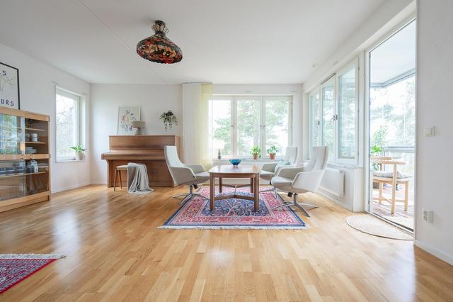 Ljust och rymligt vardagsrum med utgång till den inglasade balkongen