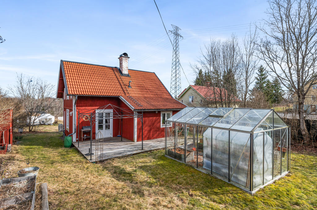 Fantastisk träveranda på husets baksida samt växthuset. 