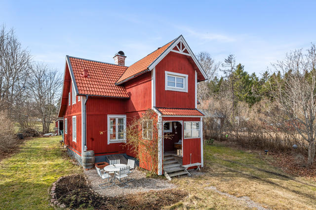 Ett charmigt rött hus med vita knutar på Kustvägen 65.
