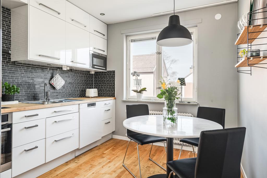 Kök i vitt med plats för matbord