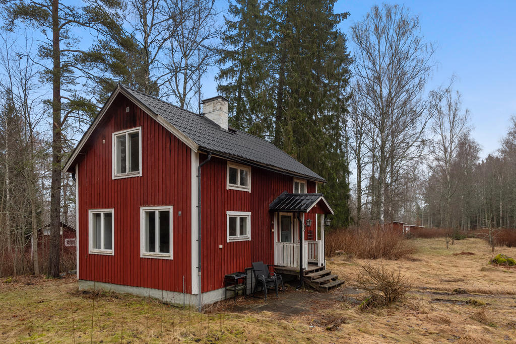 Rött hus med vita knutar som är i behov av kärlek.