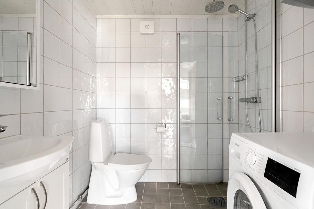 Badrum med wc, kommod, dusch och tvättmaskin