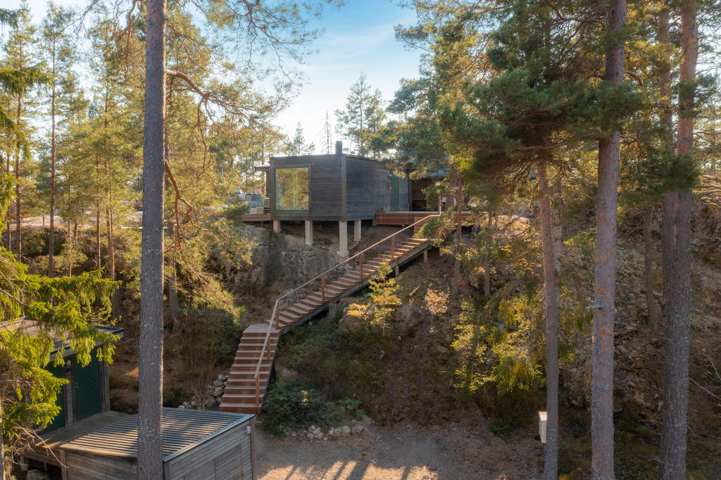Huset smälter in i ett med naturen och skogen. 