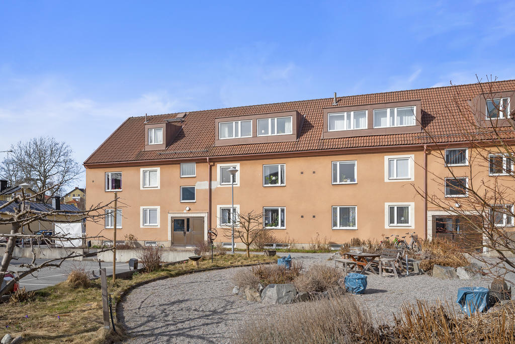 Den trevliga innergården med planteringar, grill och utemöbler