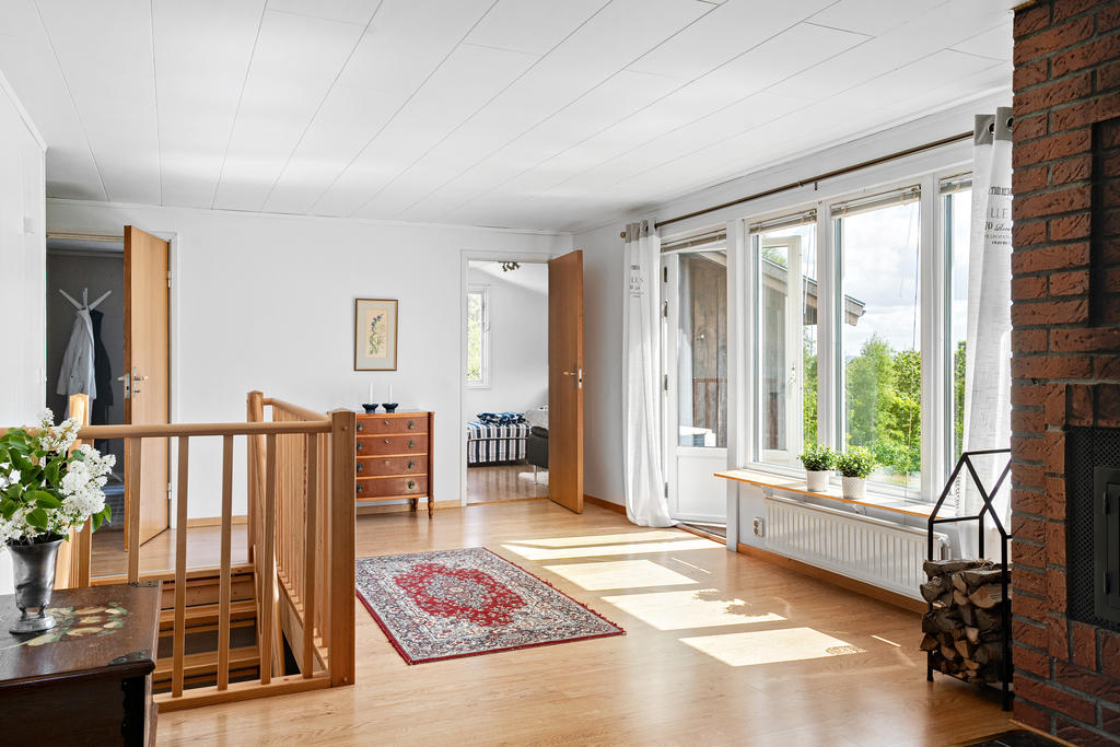 Ljust vardagsrum med nedgång till källarplanet