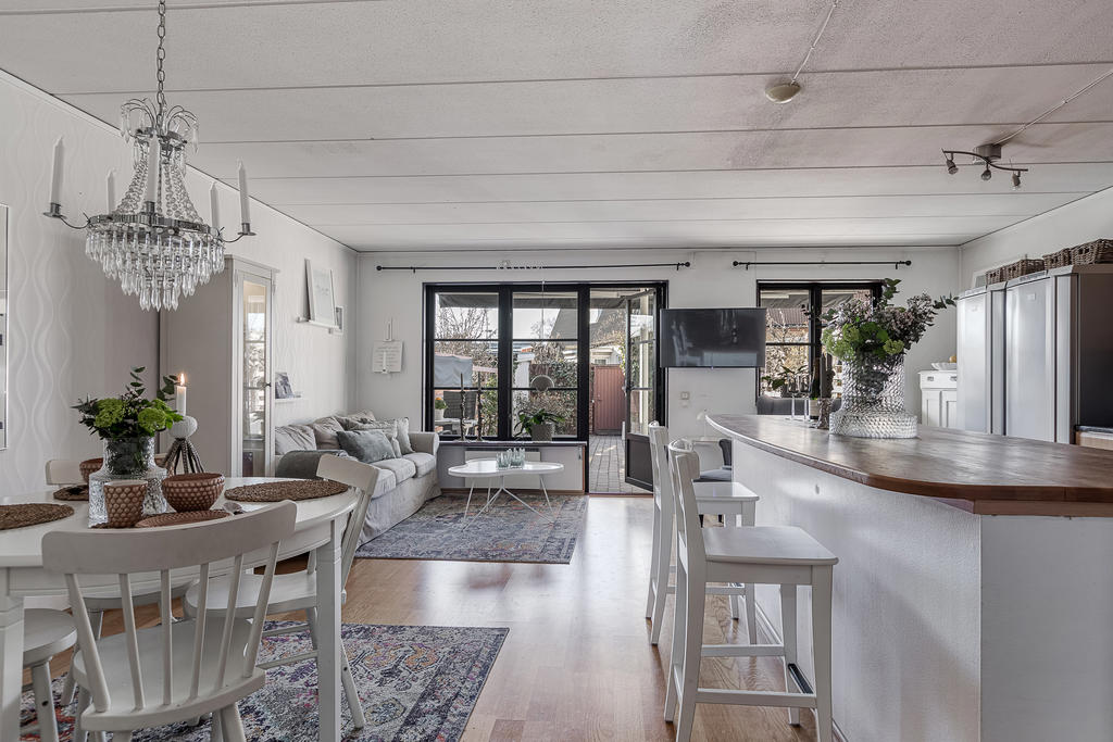 Kök och matplats med öppen planlösning och utgång till trädgårdstäppan