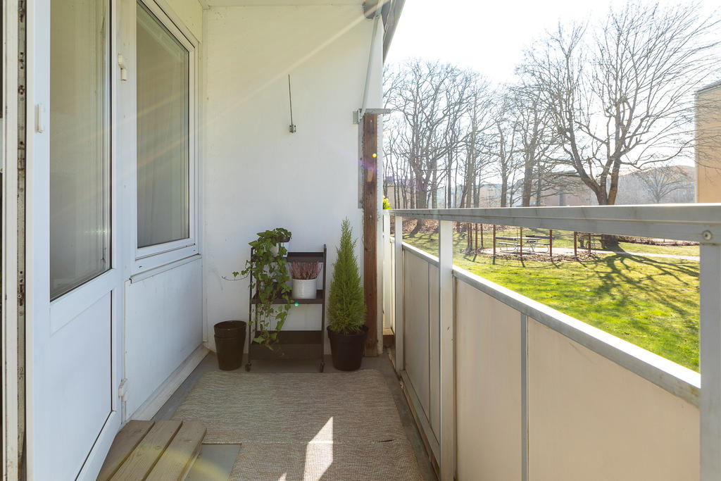 Trivsam öppen balkong med grön utsikt vår- och sommartid