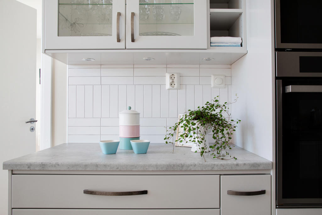 Fina detaljer i kök med dimbar belysning under överskåp och vitrinskåp  