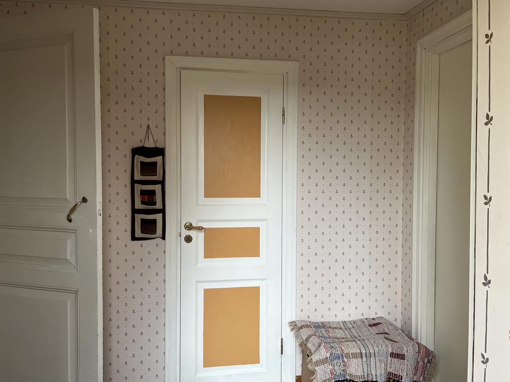Säljarens bild på hall med nymålad dörr in till badrum. 