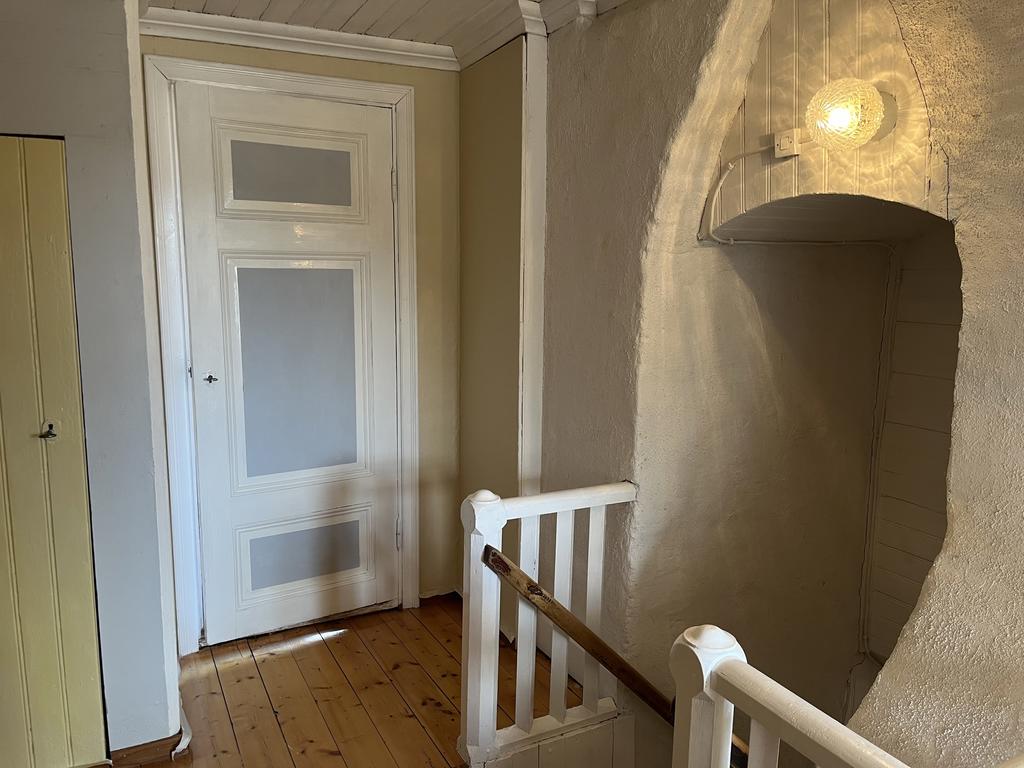 Trapphus på övervåningen med nymålade dörrar och väggar. 