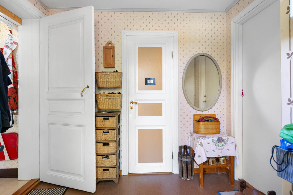 Hall med ingång till kök till vänster, badrum rakt fram och till höger in till ladan och den oinredda delen av huset. 