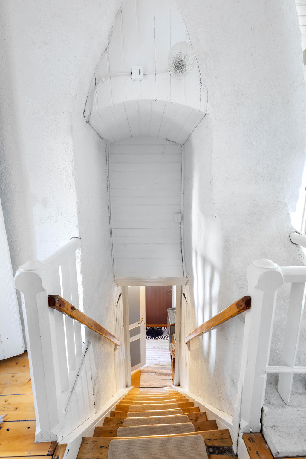 Trappen till övervåningen som går mellan den delade murstocken. 