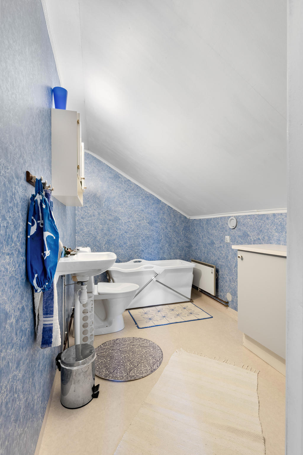 Toalettrum på övervåningen med ett portabelt badkar. 