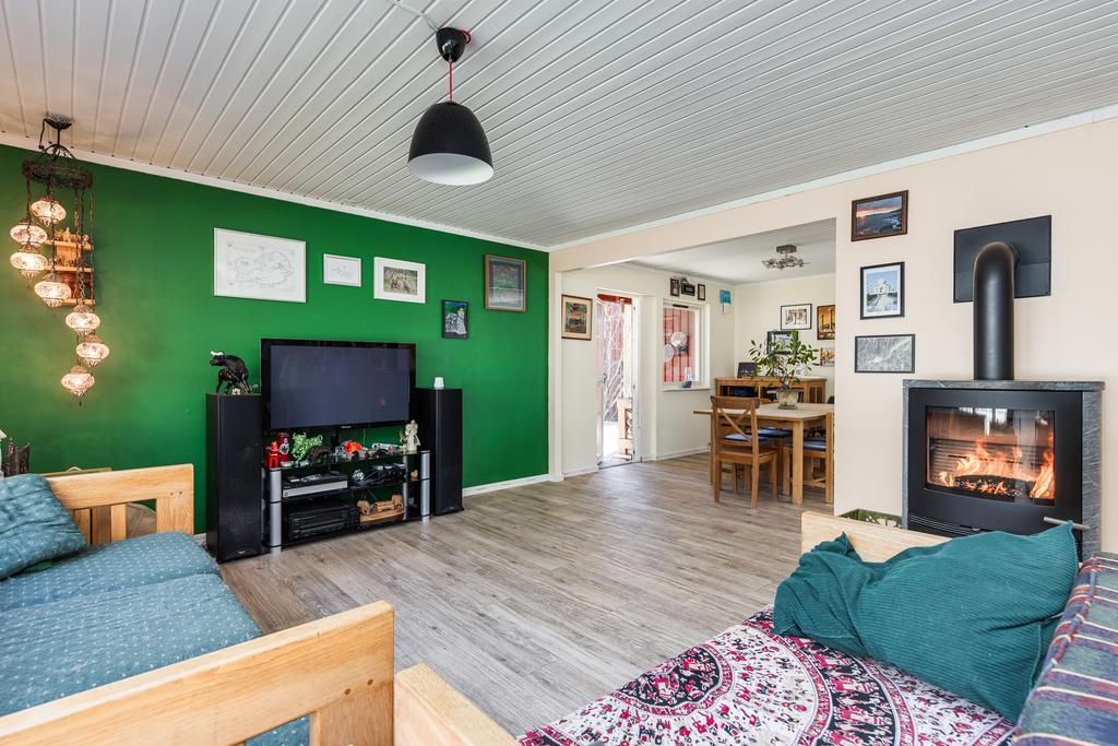 Vardagsrum med kamin och öppet mot matplats