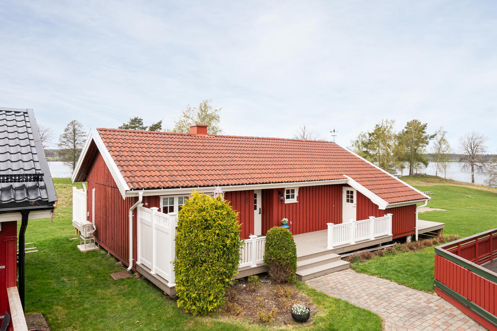 Entré med insynsskyddad veranda och vidbyggt förråd.