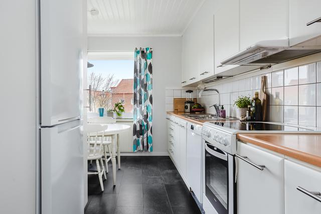 Ljust kök med plats för matbord vid fönstret