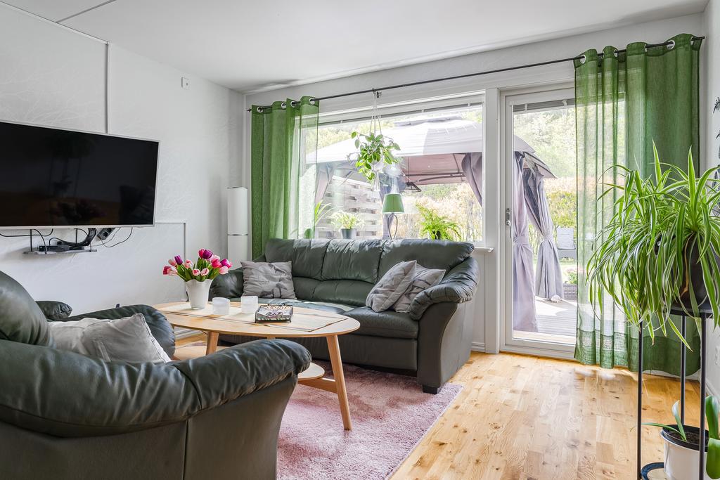 Stort fönsterparti och glasad altandörr ger skänker naturligt ljus till rummet