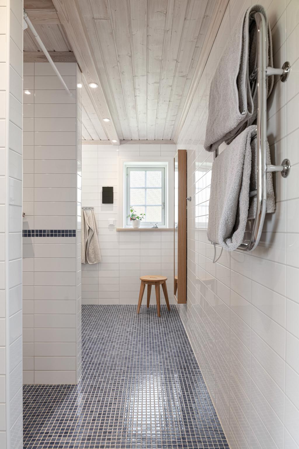 Stort badrum på entréplan med kakel och klinkers.