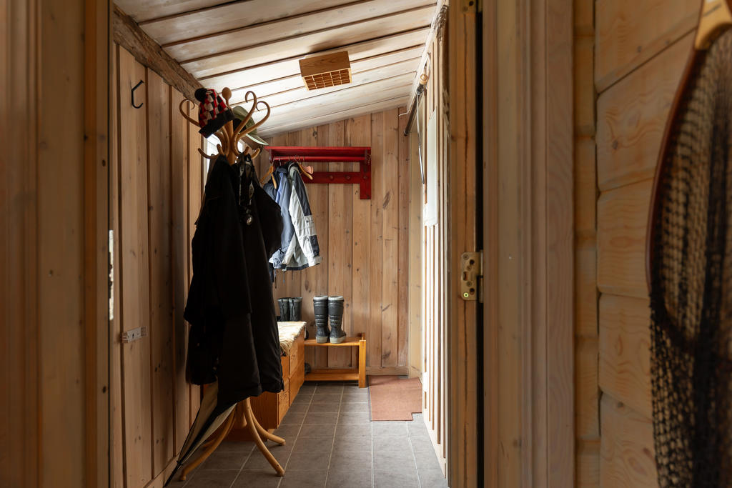Hall med klinker på golv och utrymme för ytterkläder.