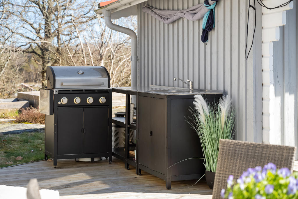 Grillplats med diskbänk och tvättho och förvaringsskåp.