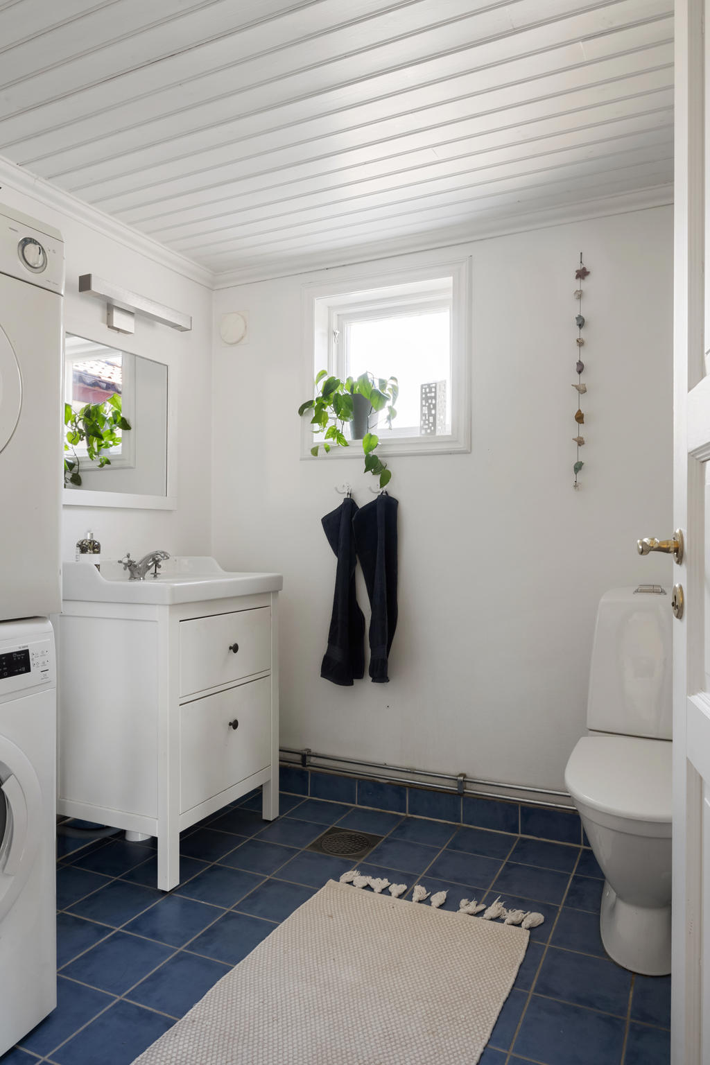 Badrum utrustat med tvättmaskin/torktumlar, wc, handfat med kommod.