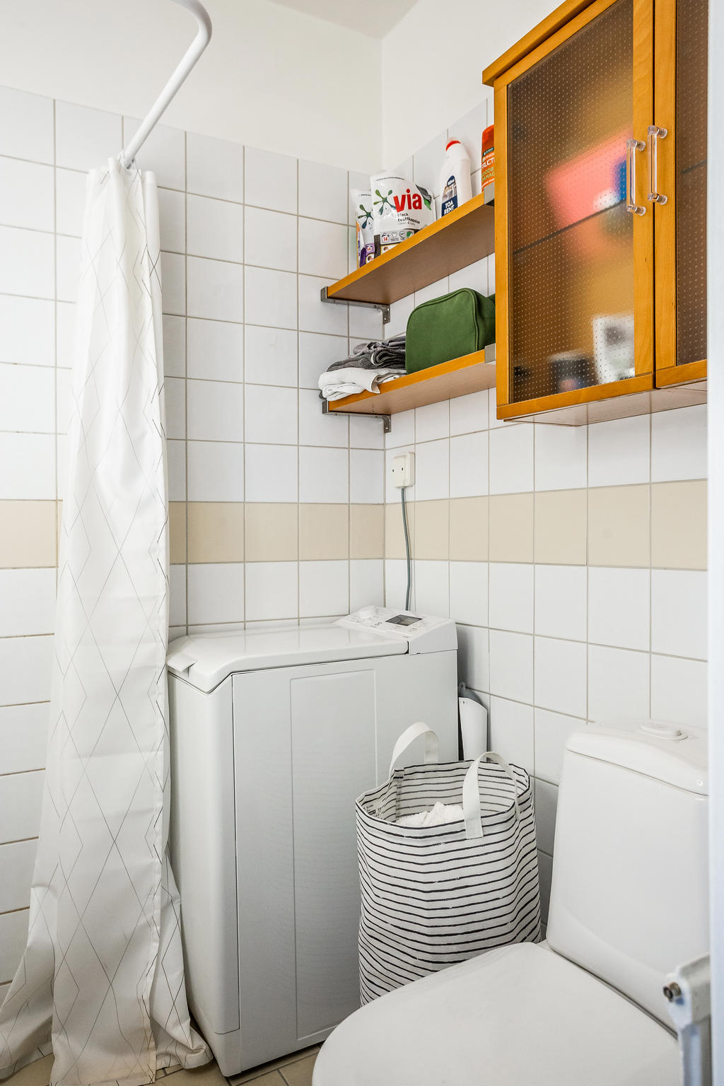 Stamrenoverat badrum utrustat med tvättmaskin.