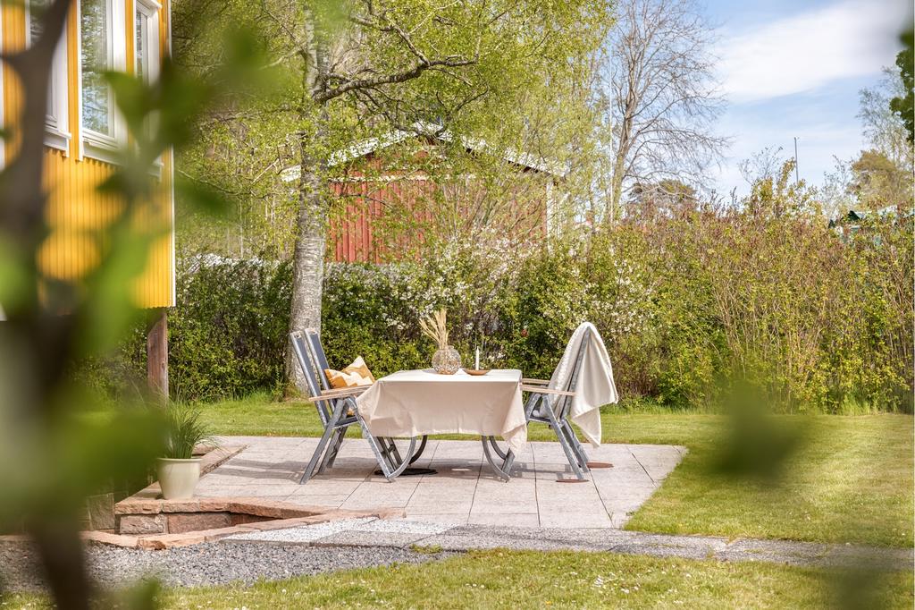Den stenbelagda uteplatsen rymmer många platser när familj och vänner kommer på besök. Grillplatsen är given på ytan snett bakom.