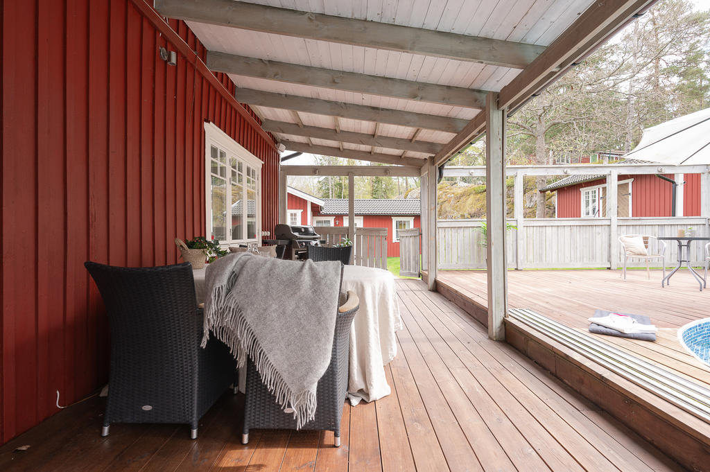Mysig uteplats under tak vid poolen