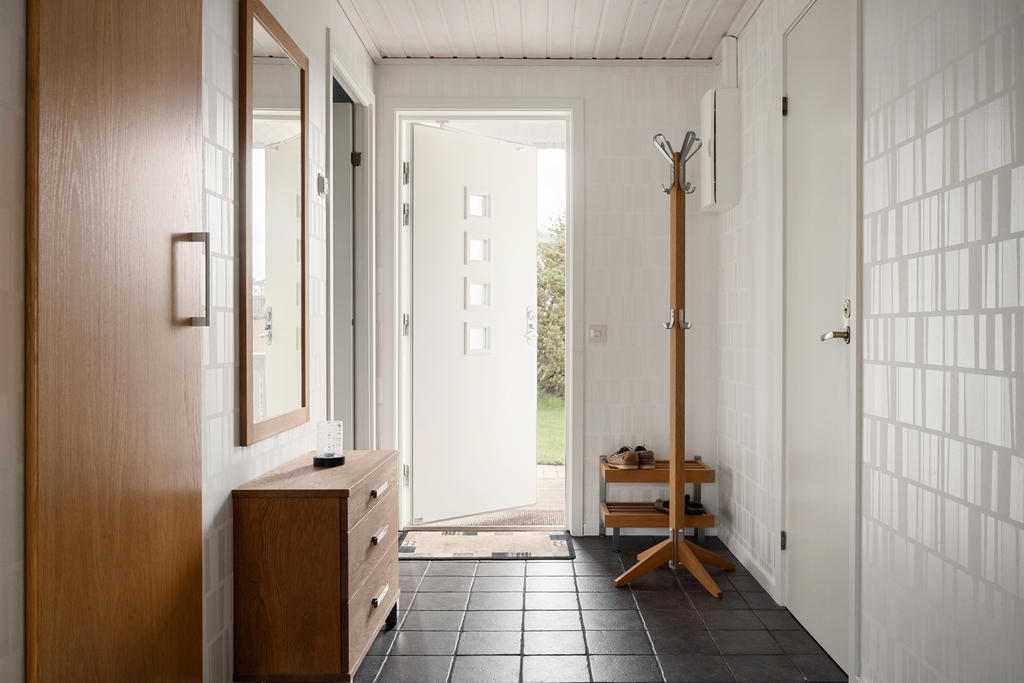 Den inbjudande hallen välkomnar med stilrent klinkergolv och praktisk avhängning för ytterkläder och skor. Här möts funktionalitet och elegans i en harmonisk entré till ditt nya hem.