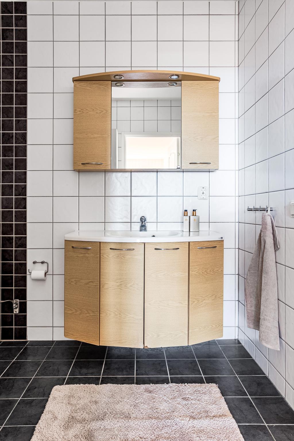 Det helkaklade badrummet går i tidlös färgsättning svart/vitt 