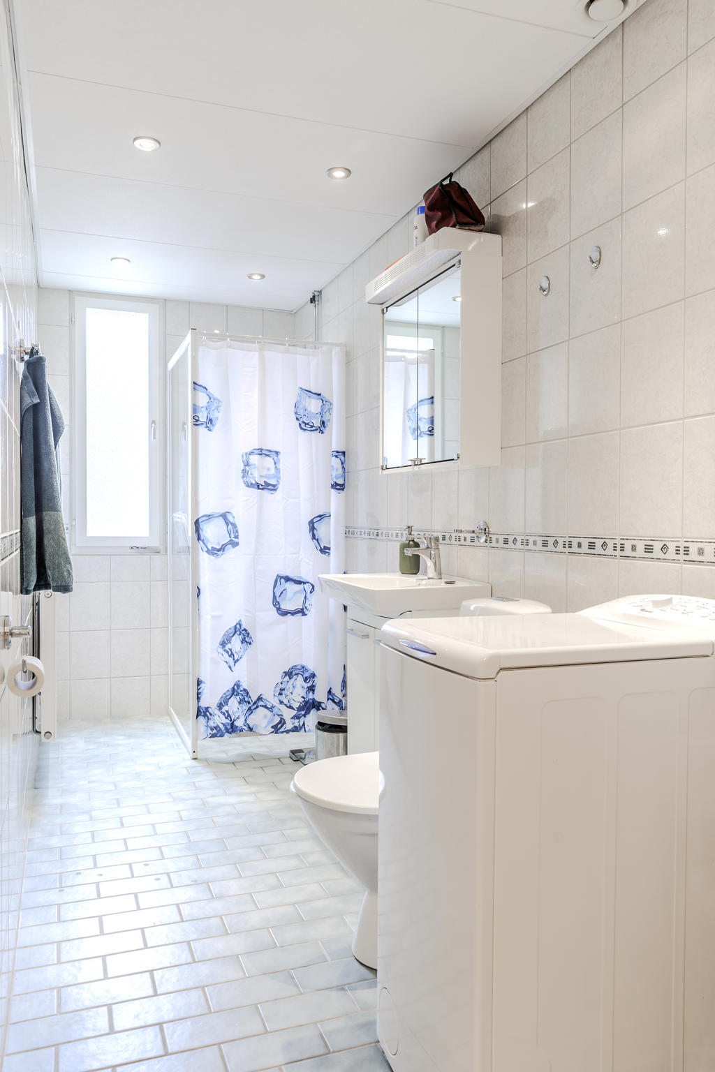 Ljust fräscht och rymligt badrum med tvättmaskin