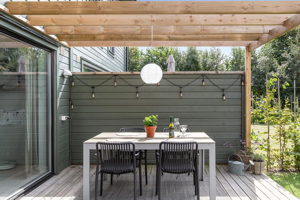 Den mysiga pergolan ger en ombonad känsla och skapar en naturlig plats för avkoppling och umgänge.
