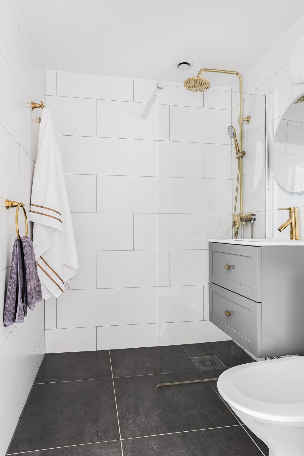 Modernt badrum med eleganta gulddetaljer