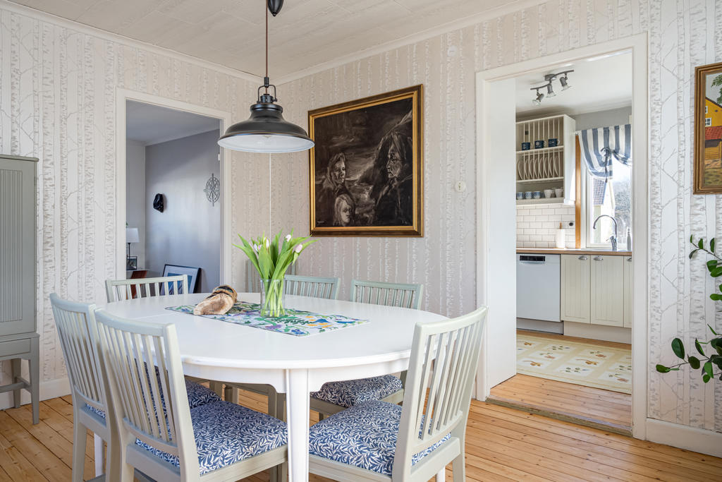 Matsal innanför köket med utgång till uterum, altan och trädgården.