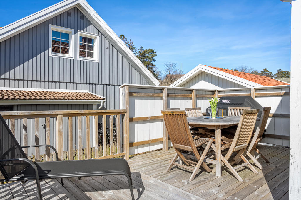 Trädäck utanför uterummet med plats för solstolar, grill och matbord med kvällsol i västerläge!