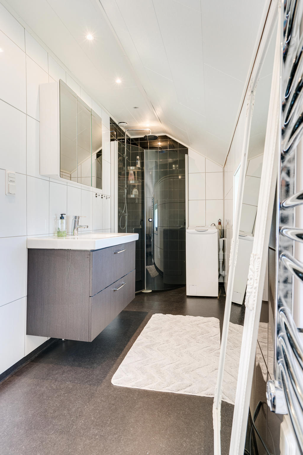 Stilrent kaklat badrum med spotlights, duschkabin, handukstork och toppmatad tvättmaskin!