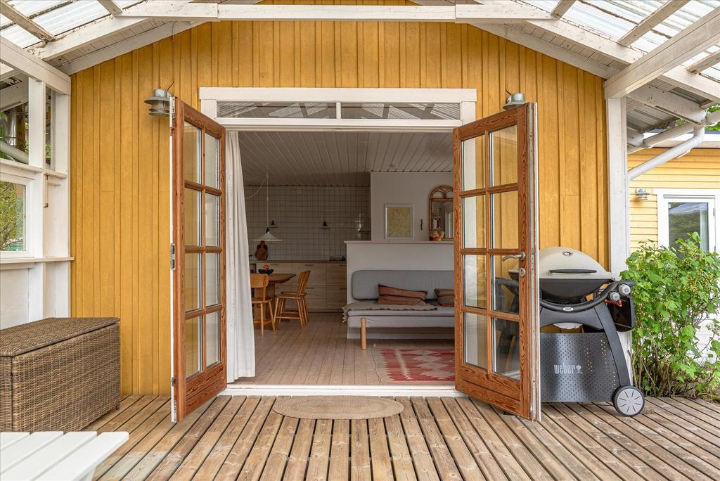 Vy från altan under tak mot vardagsrum och kök