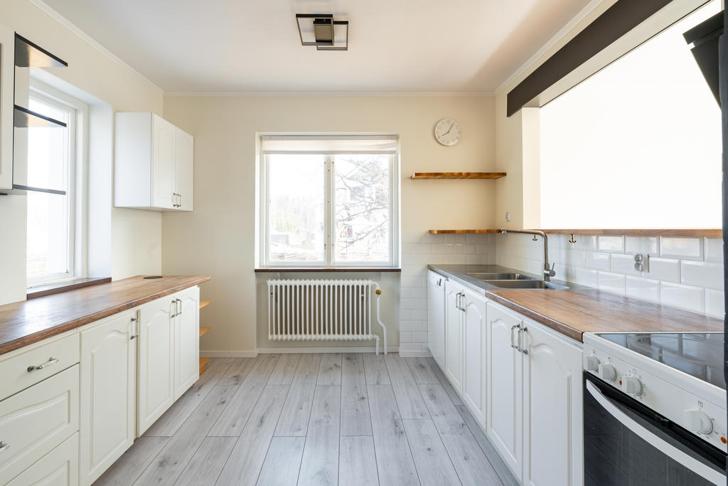 Ljust kök med gott om skåp och bänkytor