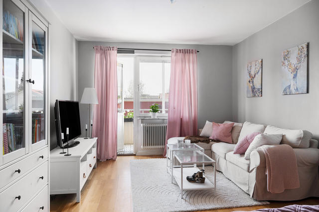 Stort och rymligt vardagsrum med utgång till balkong.