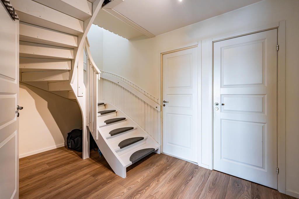 Trappa till nedre plan leder till en hall med plats för förvaring.