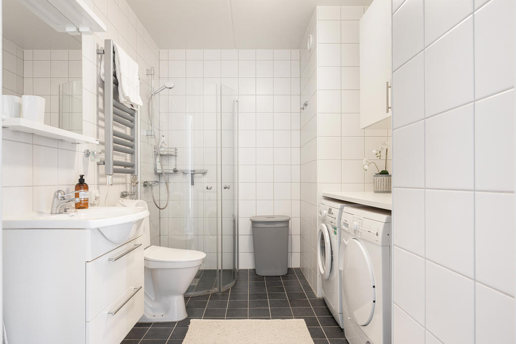 Ett stort och rymligt badrum med egen tvättmaskin och torktumlare. 