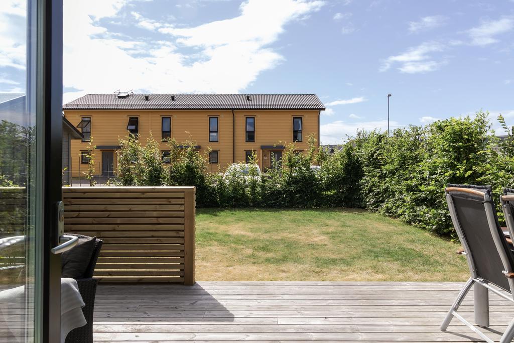 Uteplatsen på baksidan med viss del trall och viss del gräsyta