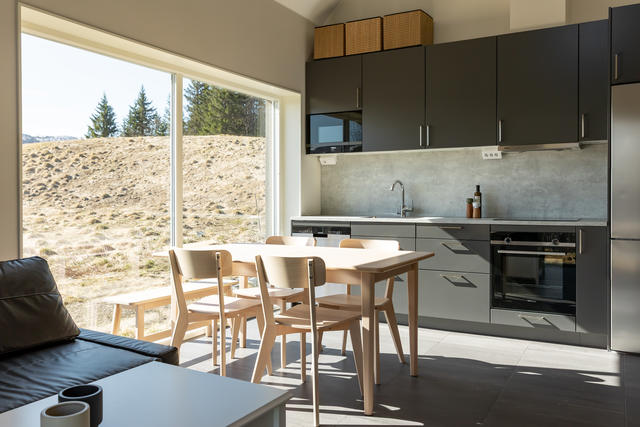 Kök och vardagsrum i öppen planlösning med stora fönsterpartier mot söder