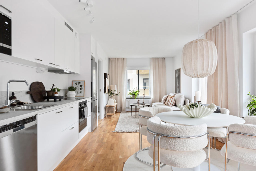 Socialt kök med ljusa skåpsluckor och rostfria vitvaror.