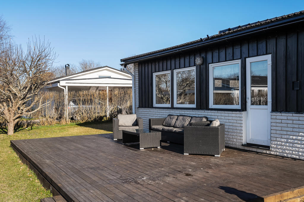 Härlig uteplats på husets baksida med plan gräsmatta,