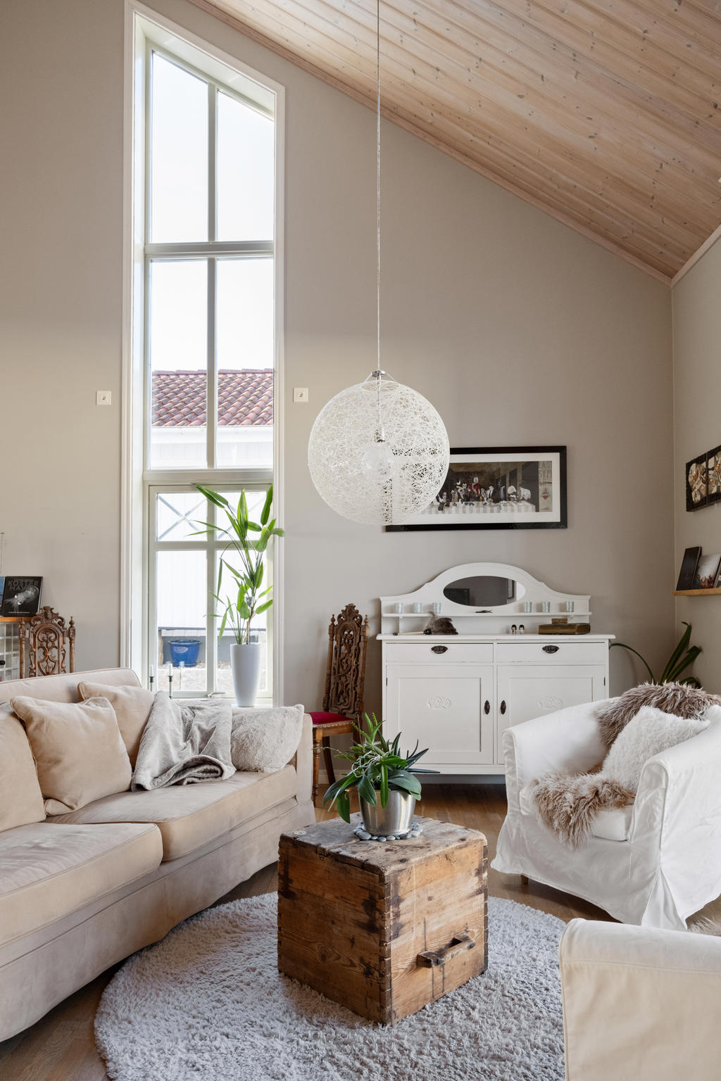 vardagsrum med höga pampiga fönster.